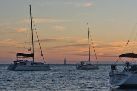 Beautiful colours of Sunset in Dalmatia, Croatia with yachts on the seaの写真素材