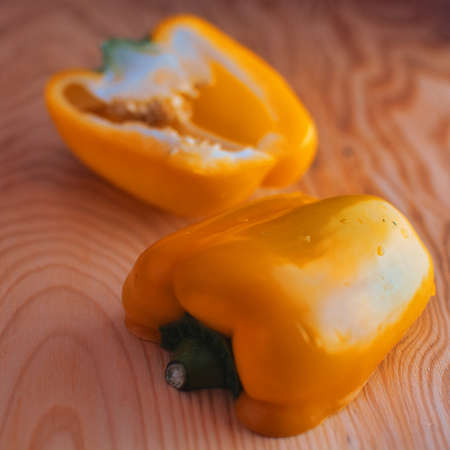 Yellow Pepper cut apart on a wooden backgroundの写真素材