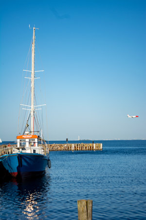 Copenhagen, Denmark, June 2023 :Sailboat lying in the harbor with view on the resundの写真素材