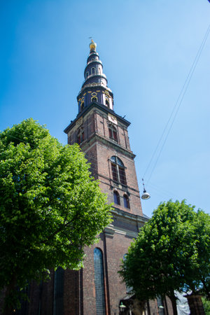 A vertical shot of the Church of Our Savior under the blue sky captured in Copenhagen, Denmarkの写真素材
