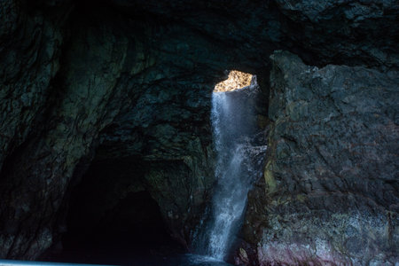 Large cave with clear fresh water near Kalalau Beach in the Na Pali Coast State Park on the island of Kauai, Hawaii USA.の写真素材