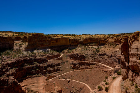 Shafer Trail Viewpoint offers an overlook of the canyon landscapes below. Perched high above, the vantage point provides a perspective of Shafer Trail winding through the iconic Canyonlands.の写真素材