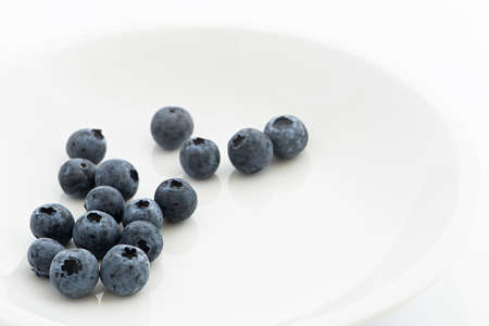 Fresh blueberries on a white plateの写真素材