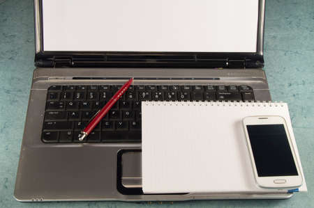 Notepad, pen, laptop and cell phone with copy space.