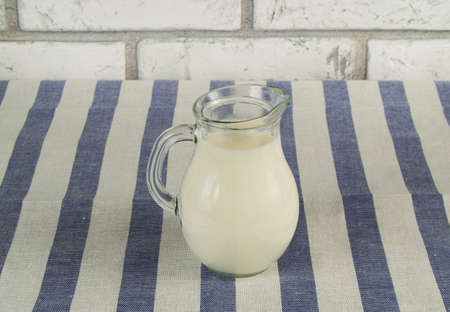 Milk in glass jug on a napkin.の写真素材
