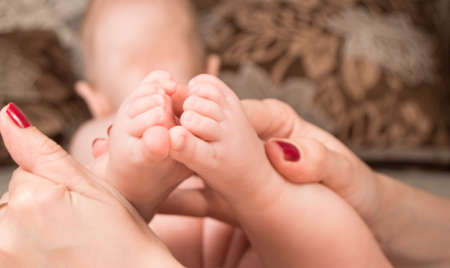 Baby feet in mother hands. Mom and her Child. Happy Family concept