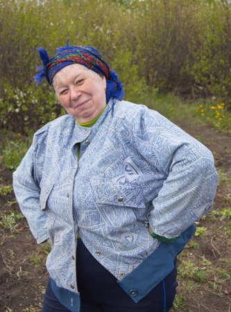 Smiling elderly woman in a headscarf in your garden.の写真素材