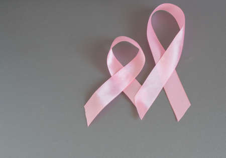 Two pink ribbons to raise awareness about breast cancer, the image on a gray background, copy space.の写真素材