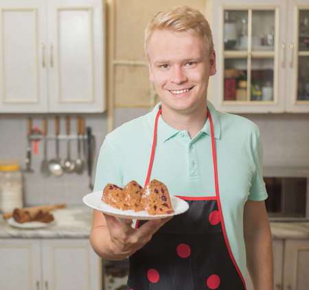 happy smiling male pastry chef holding a delicious cake.
