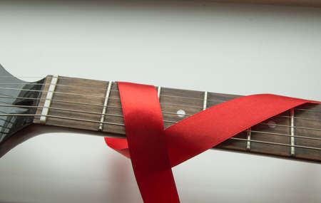 guitar, rock music and red ribbon - symbol of fight against AIDS.の写真素材