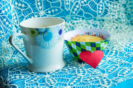 Cup of coffee, cupcake and hearts on the doily card with copy space.の写真素材