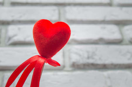 Valentines day red hearts on white blurred background a brick wallの写真素材