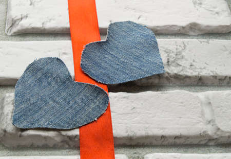 Two Denim hearts Valentines Day background of white brick wallの写真素材