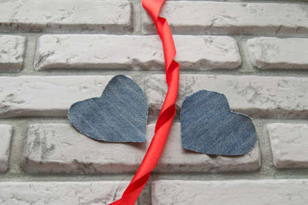 Two Denim hearts Valentines Day background of white brick wallの写真素材