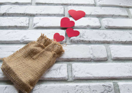 Valentines day, red hearts canvas bag, background white brick wallの写真素材