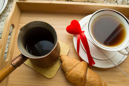 Valentines day Breakfast croissant and coffee is served in a tray with heartの写真素材