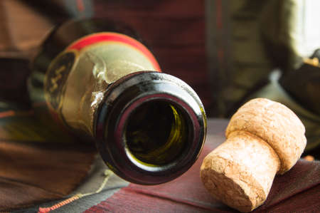 Open bottle of champagne and the cork on table with a tableclothの写真素材