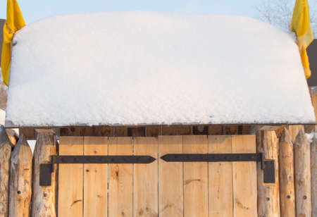 wooden gate in the fence on a Sunny winter dayの写真素材
