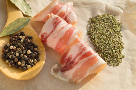 Delicious bacon rolls and a wooden spoon with spicesの写真素材