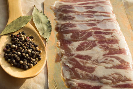 Delicious bacon and a wooden spoon with spicesの写真素材