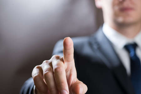 Businessman click on virtual touchscreen. Futuristic business and IT presentation backgroundの写真素材