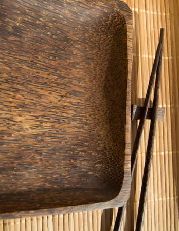 Empty wooden plate and sushi chopsticks on bamboo napkinの写真素材