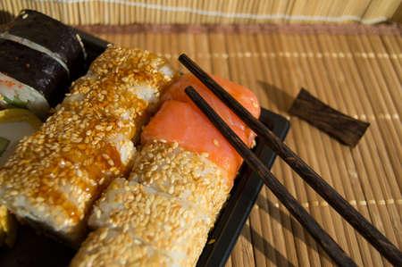 Traditional Japanese food - sushi set, chopsticks on bamboo backgroundの写真素材