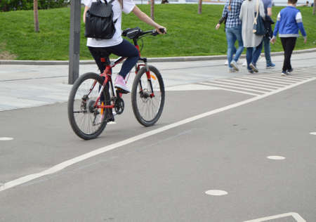 Girl on bike with backpack rides in the Park in the summer.の写真素材