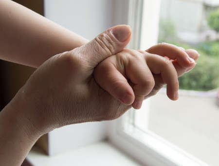 concept of a happy family - an adult holds the hand of a babyの写真素材