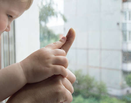 concept of a happy family - an adult holds the hand of a baby.の写真素材