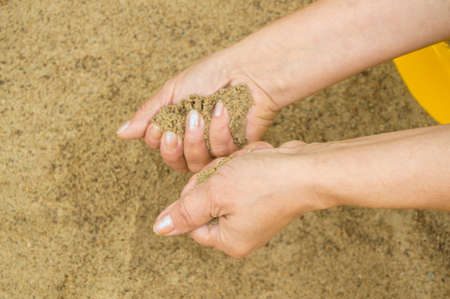 Female hands with sand, the concept of vacation and holidaysの写真素材