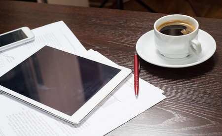 Workplace of businessman with digital tablet, smartphone, Cup of coffee and charts. The concept of a startup businessの写真素材