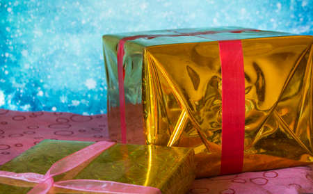 Two shiny gift boxes for Christmas on a blue background.の写真素材