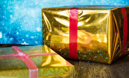 Two shiny gift boxes for Christmas on a blue background.の写真素材