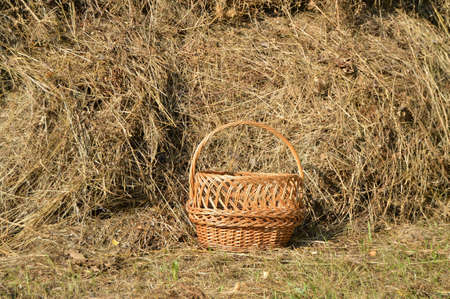 Wicker picnic basket and a haystack - beautiful rural background in Sunny summer dayの写真素材