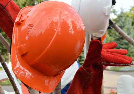 Closeup of a red protective helmet and gloves, outdoor.の写真素材