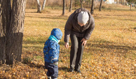 Woman and small child playing together in autumn Parkの写真素材