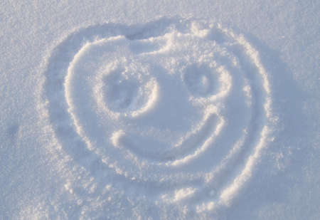 Smiling face is drawn on a snow.の写真素材