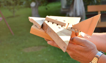 Homemade wooden toy airplane in the hands of men, the concept of journey, dreams, freedom, playing with the childの写真素材