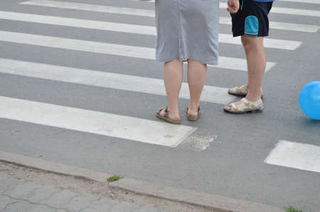 A couple of older man and woman standing at the crosswalk and talkingの写真素材