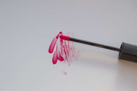 beautiful pink lip gloss smear with brush, isolated on white background.の写真素材