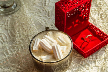 Coffee Cup with marshmallows ring in a box on the table with lace tablecloth, surprise concept for womanの写真素材