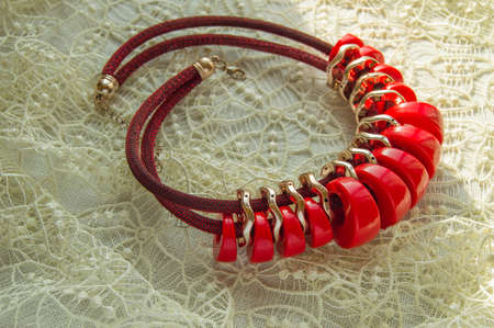 Beautiful accessory - a red beaded necklace, necklace, fashion jewelry lies on Lacy napkinの写真素材