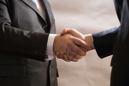 Business handshake of two businessmen in suits, negotiate and make a dealの写真素材