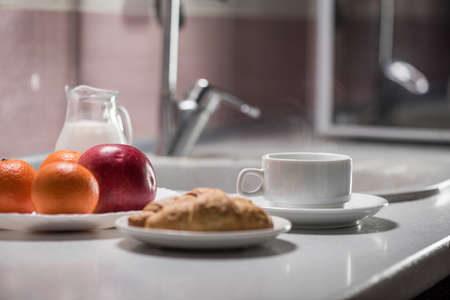 healthy Breakfast in the kitchen with coffee, croissants, milk and fruit