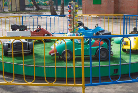 Colorful cars for children on a merry-go-round, fun in the Parkの写真素材