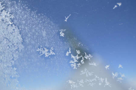 Snowflakes on the window of the plane. In the background, through the window you can see the blurred...