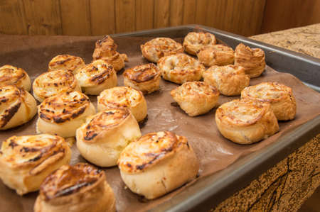 Freshly baked homemade cinnamon rolls lie on a baking sheet.の写真素材