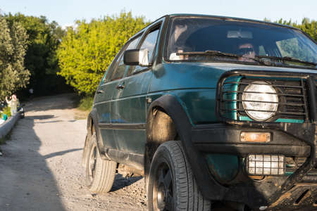 Dirty blue SUV on the road on a Sunny summer day