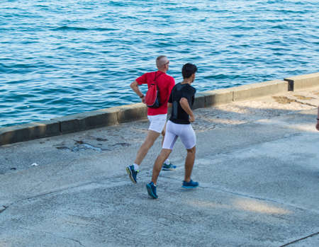 A boy pulls a large green buoy from behindの写真素材